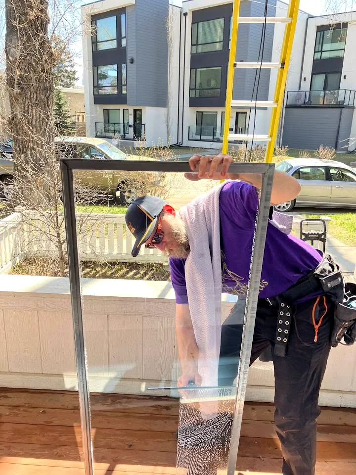 Mystic Windows cleaning a window screen by hand