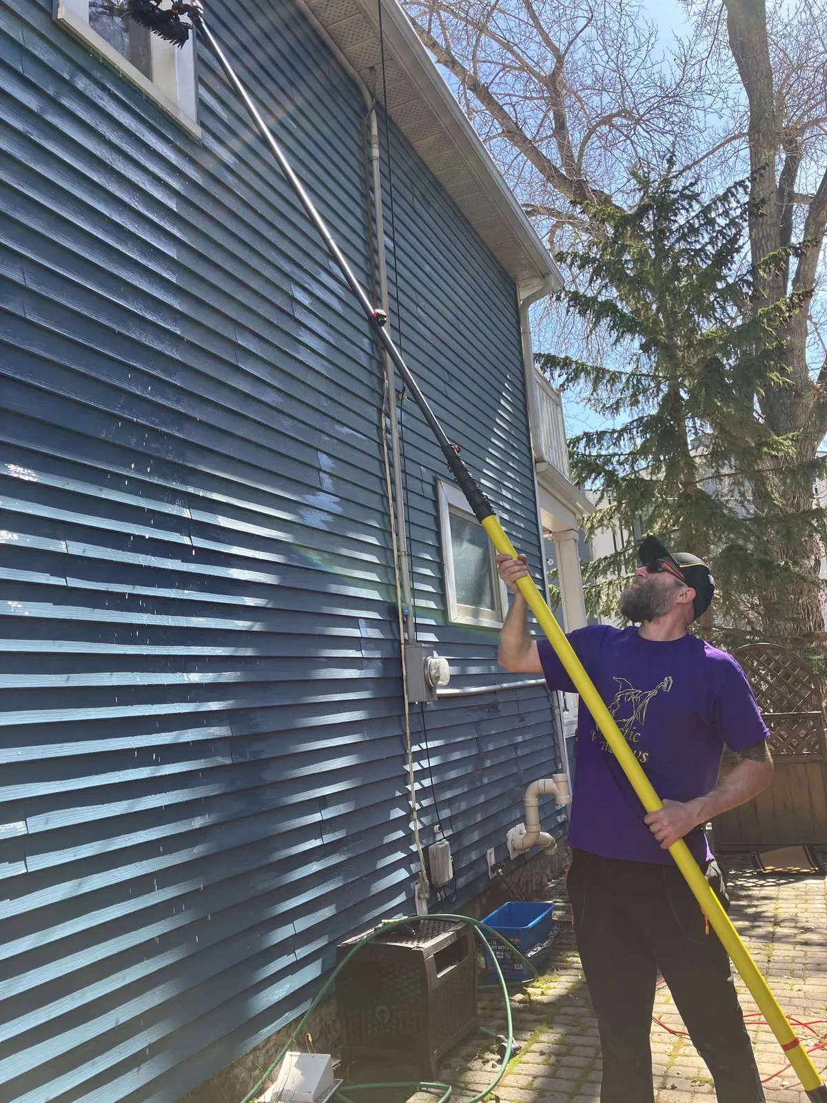 Mystic Windows professional cleaning an upper-storey window with a water-fed pole